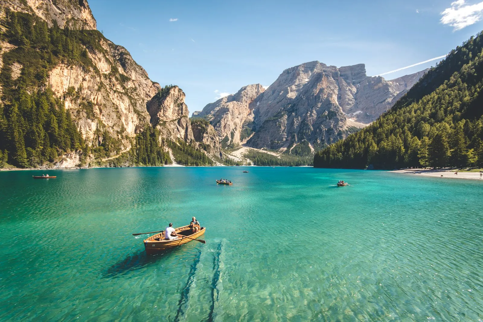 Turquoise mountain lake surrounded by forest and rocky peaks